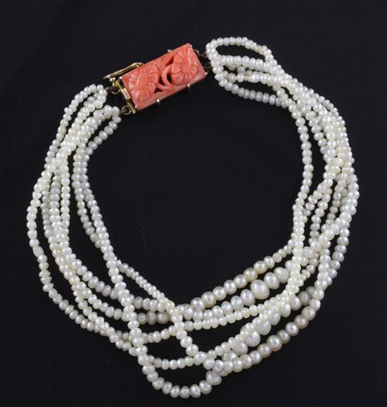 A multi strand natural pearl bracelet with carved coral set gold clasp, approx. 6.5in.